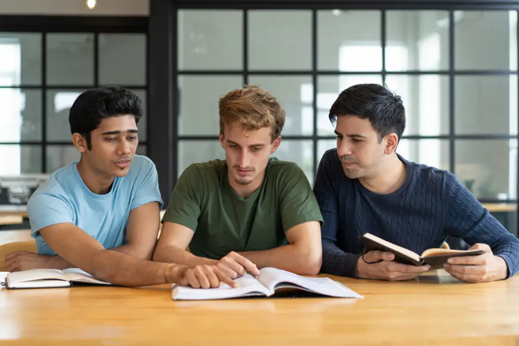 A group of male students struggling to do a project for their college writing class